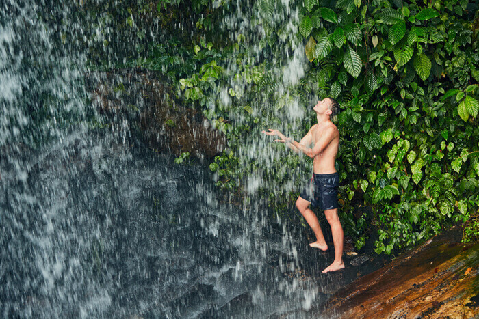 Man In Waterfall filled with Negative Ions - Health Benefits